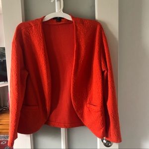 Quilt like orange long sleeved comfort jacket.